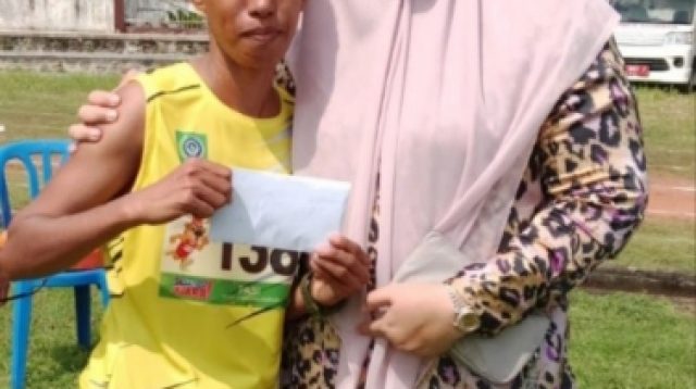 Bupati Bima Hj. Indah Damayanti Putri saat memberikan bonus pada Syarafiah peraih medali emas lari Maraton. Foto: Ist